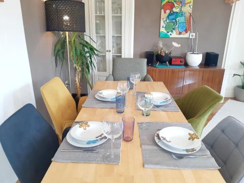 a wooden table with plates and glasses on it at Große Altbauwohnung auf dem Land in Kallham