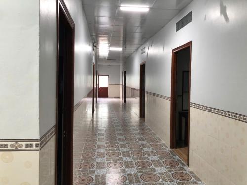 an empty hallway with a tile floor and doors at Nhà Nghỉ THANH LIÊM in Cà Mau