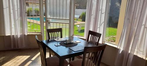 a table and chairs in a room with a window at Dzana guesthouse in Klerksdorp