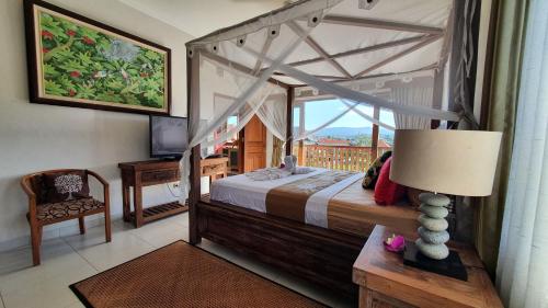 Un dormitorio con una cama con dosel y una ventana. en Villa Santai Karangasem, en Tirtagangga