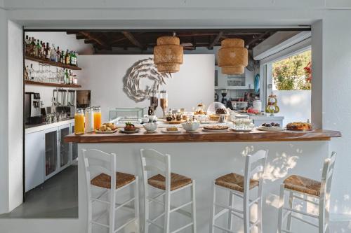 a kitchen with a breakfast bar with chairs at Aeolos Hotel & Villas - Pelion in Chorefto