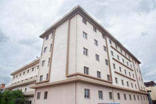 a large white building with a triangular top at Dunia Hôtel Bamako ACI 2000 in Bamako