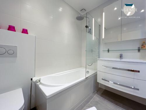 une salle de bain blanche avec une baignoire et un lavabo dans l'établissement Villa Jade, à Grimaud