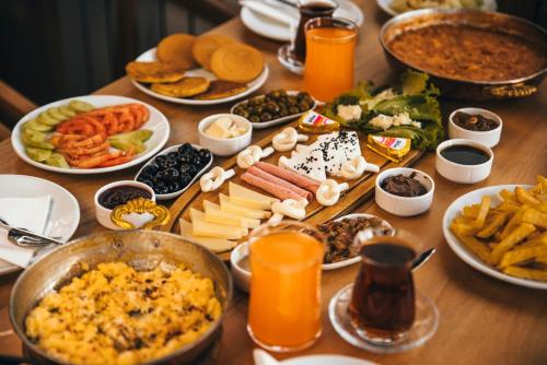 a table topped with plates of food and orange juice at Lubberona Cave Cappadocia in Nar