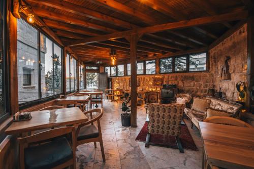 a restaurant with tables and chairs and windows at Lubberona Cave Cappadocia in Nar