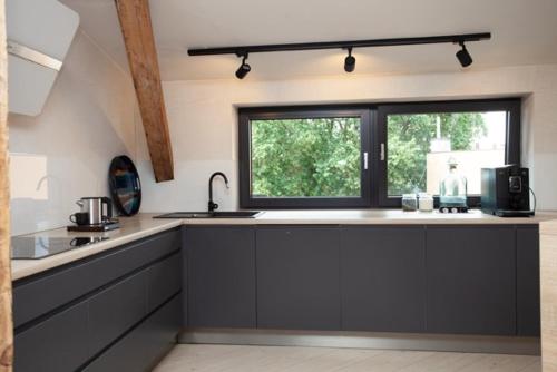 a kitchen with a sink and a window at "Przy Rynku" pokoje z prywatnymi łazienkami in Gliwice