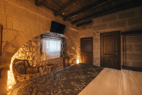 a bedroom with a bed in a stone room at Lubberona Cave Cappadocia in Nar