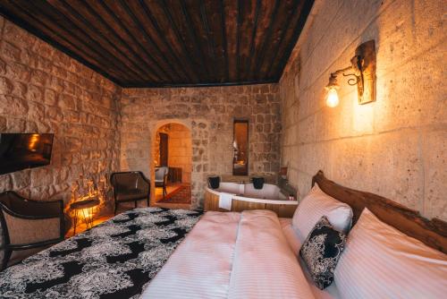 a bedroom with a bed in a stone wall at Lubberona Cave Cappadocia in Nar