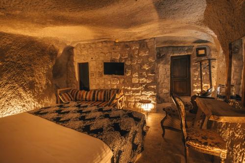 a bedroom with a bed in a stone room at Lubberona Cave Cappadocia in Nar