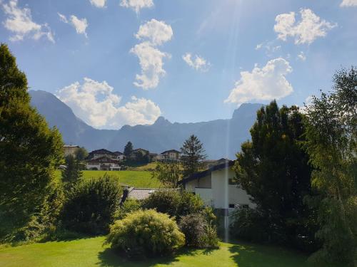 a house in a field with mountains in the background at Apartments Almstein in Abtenau