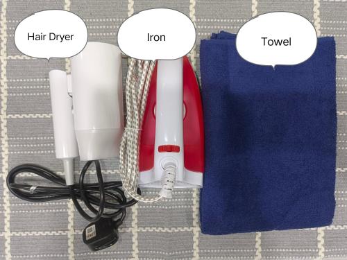 a red and white hair dryer next to a blue bag at Sterizon Home in Kluang
