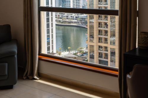 a room with a window with a view of a harbor at Prime Spacious 5 Plus 1 BR Apt On JBR Beach near Metro ,Walk to The Mall, Dining & Entertainment - By Sunkissed Holiday Homes in Dubai