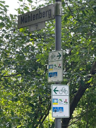 two street signs on a pole in front of trees at Ferienwohnung Idyll - Alleinlage in Berge
