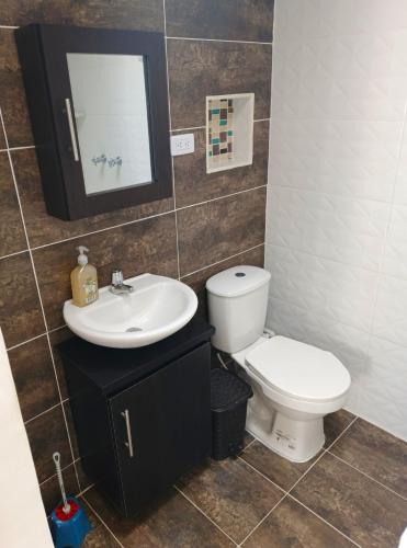 a bathroom with a toilet and a sink at Comodas y agradables Habitaciones en Chipre in Manizales