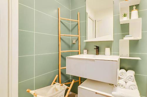 La salle de bains est pourvue d'un lavabo blanc et de carrelage vert. dans l'établissement 