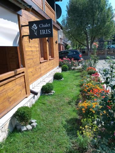 a sign on the side of a building with flowers at Chalet Iris with sauna in Kolašin