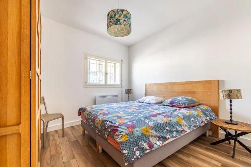 ein Schlafzimmer mit einem Bett und einem Tisch mit einer Lampe in der Unterkunft Paris La Defense - Refurbished independent house in La Garenne-Colombes