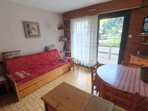 un salon avec un canapé rouge et une table dans l'établissement Appartement cosy à Châtel, 100m des pistes, 4 pers., terrasse sud, équipements cuisine complets - FR-1-676-185, à Châtel