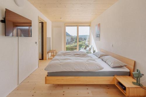 Un dormitorio con una cama y una ventana grande. en Raum 7 Ferienwohnung, en Monschau