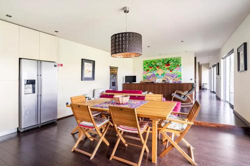 a dining room with a wooden table and chairs at Casa Nova in Guimarães