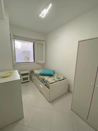 a white room with a bed and a window at Casa Plumeria in Marinella di Selinunte