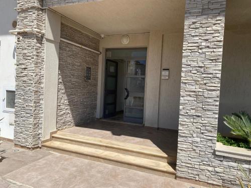 a door to a building with a brick wall at Panorama Apartment Zone Touristique Haut Standing in Mahdia