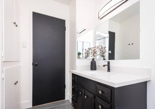 a bathroom with a black and white sink and a mirror at Main Street Retreat in Roseville