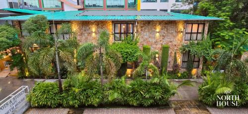 a building with a bunch of trees in front of it at Hotel North House - Best Boutique Hotel in Haldwani in Haldwāni