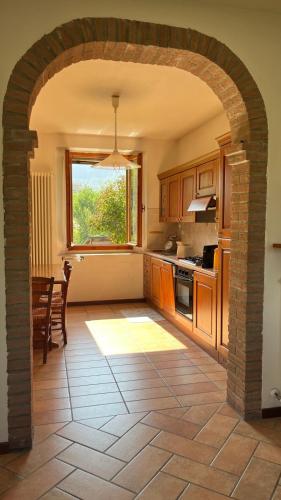 an archway in a kitchen with a table and a window at Ca' Rivella - paceful country living in Villa dʼAiano