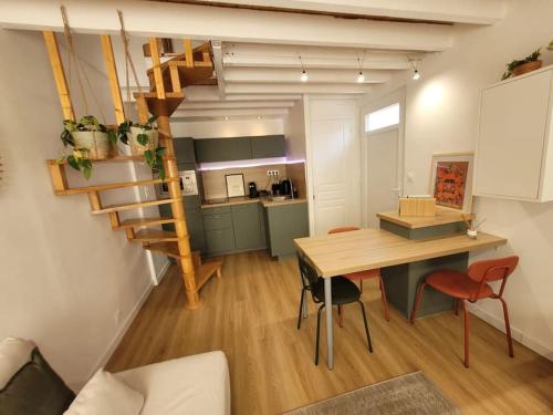 une cuisine et une salle à manger avec une table en bois et un escalier dans l'établissement Petite maison pleine de charme, à Lambersart