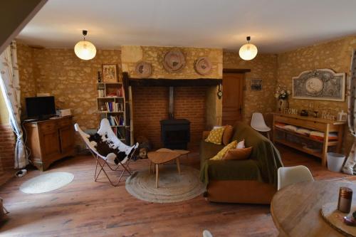 a living room with a couch and a fireplace at Les Girouteaux La bergerie in Les Eyzies-de-Tayac