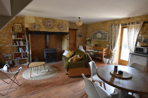 a living room with a couch and a table at Les Girouteaux La bergerie in Les Eyzies-de-Tayac