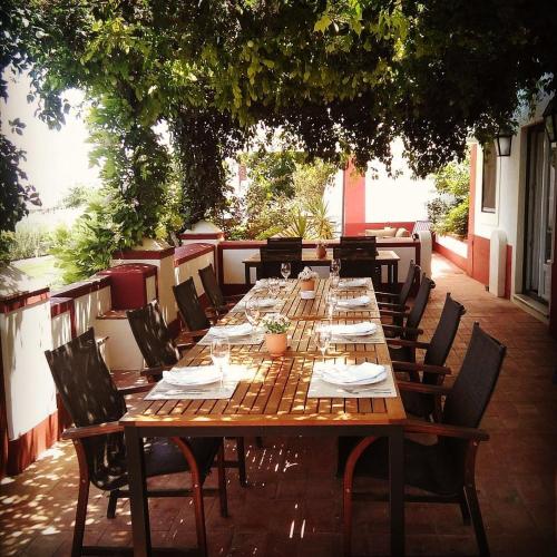a long wooden table and chairs on a patio at Hotel Rural Monte da Provença in Elvas