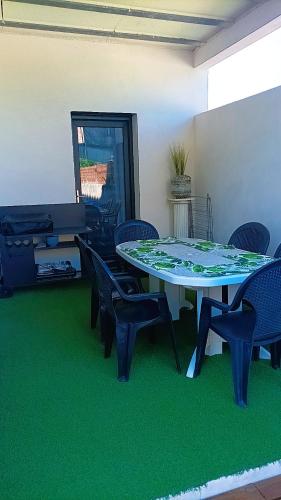 a room with a table and chairs and green carpet at Villa Belles étoiles en Cévennes classée 3 étoiles avec piscine privée dans le Gard in Ribaute-les-Tavernes