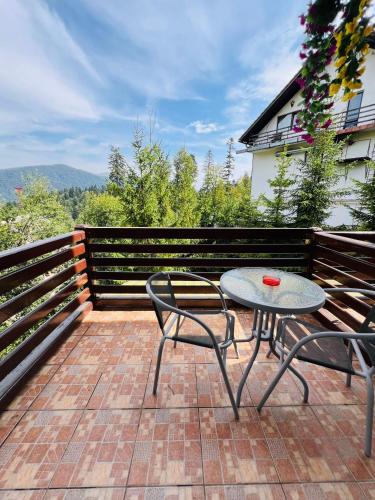 a patio with a table and two chairs on a balcony at Ski Chalet Sinaia in Sinaia