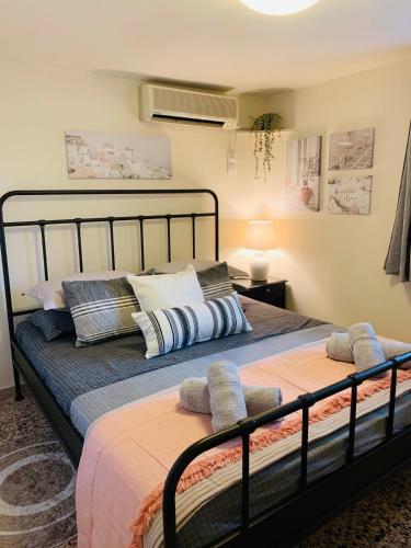 a bed with two pillows on it in a room at Airport Cottage House in Artemida