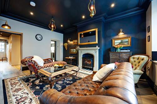 a living room with a couch and a fireplace at Croft House in High Bentham