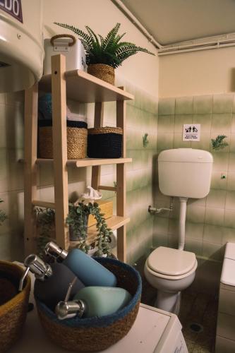 a bathroom with a toilet and a sink with plants at Airport Cottage House in Artemida