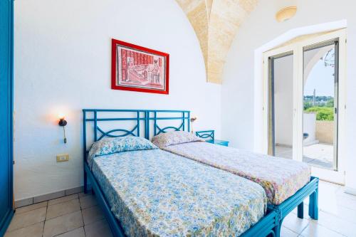 a bedroom with a bed with a blue frame and a window at Casa delle sorgenti in Torre Vado
