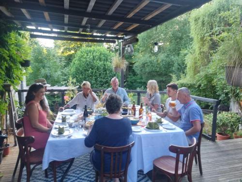 a group of people sitting around a table in a garden at L'AnciennePoste in Bugeat