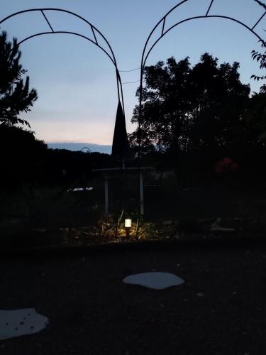 a silhouette of a gate with a sunset in the background at Une escale gourmande in Eyzerac