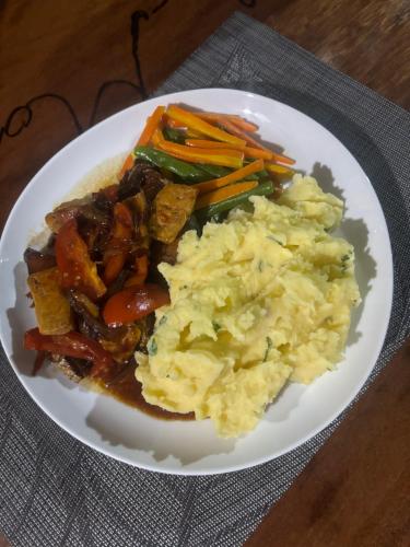 a plate of food with potatoes and vegetables on a table at Moile Moile Surfcamp in Masokut