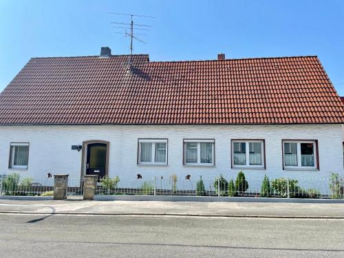 a white house with a red roof on a street at Villa Rosa in Bad Rodach