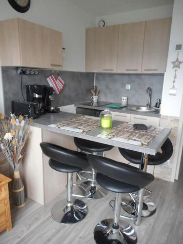 - une cuisine avec un comptoir et des tabourets de bar dans l'établissement Appartement PuySaintVincent 1600, à Puy-Saint-Vincent