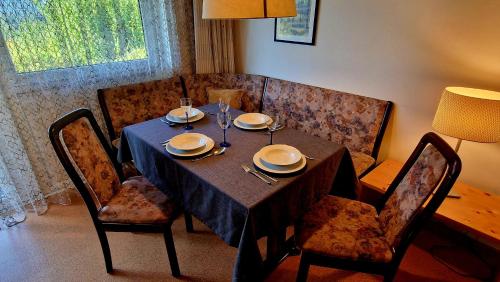 a dining room table with chairs and a table with plates and napkins at Dachsteinblick in Bad Aussee