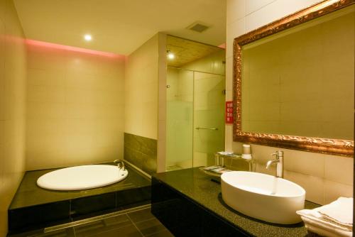 a bathroom with a sink and a mirror at Belle Song Motel in Shulin