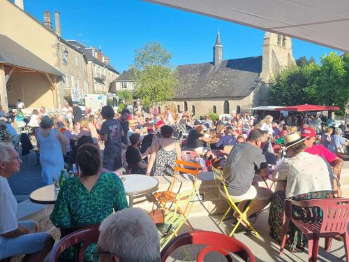 a crowd of people sitting at tables in a crowd at L'AnciennePoste in Bugeat