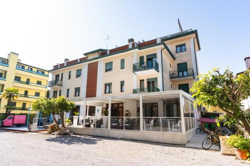 a large building with a balcony in a street at Hotel Regina in Caorle