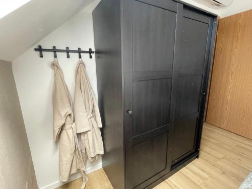 a closet with a black door and towels at Villapark Vonyarcvashegy Libella in Vonyarcvashegy