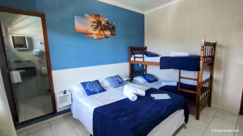 a hotel room with two beds and a shower at Pousada Baía dos Corais in Penha